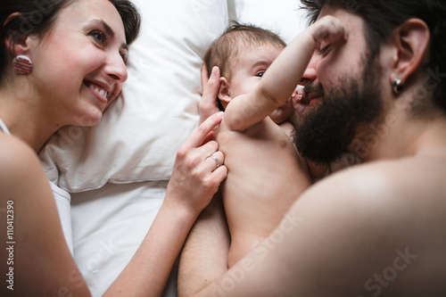 mom, dad and daughter in bed
