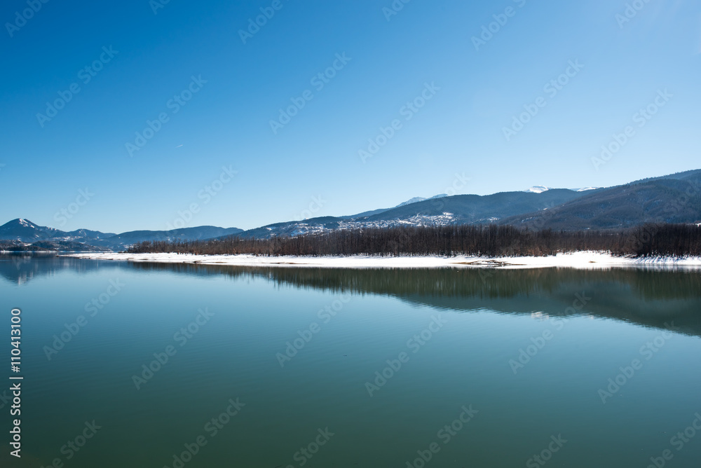 Tranquil scenery. Landscape, Black snowy mountain, clear sky on lake at a winter day, Greece