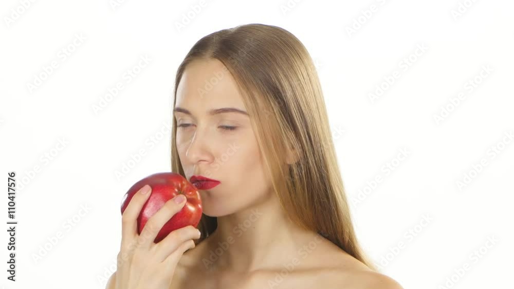 Blonde girl with braces eating a big red apple. White. Closeup Blonde girl with braces eating a big red apple. White. Closeup
