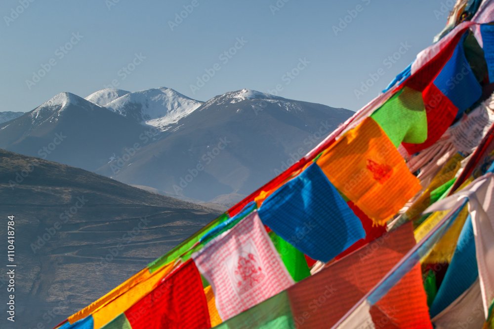 Snow mountain in China Southwestern in Sertar County of Garze Tibetan Autonomous Prefecture, in Tibet, Kham, China, with blurred prayer flags in foreground