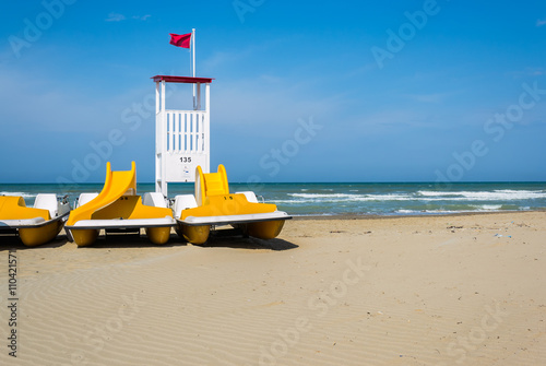 pedalò e postazione del bagnino di salvataggio in spiaggia photo