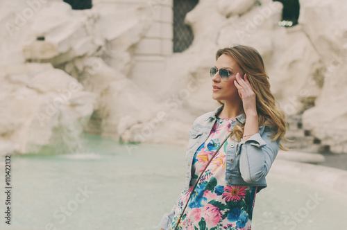 Pretty woman looking to the fountain of Trevi during her trip in