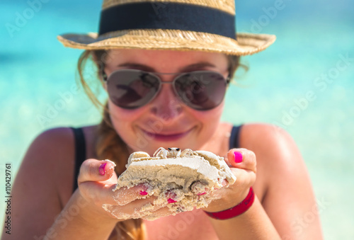 beautiful young woman smiling and holding a crab on beach