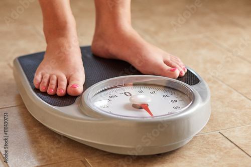 Female feet on weight scale photo