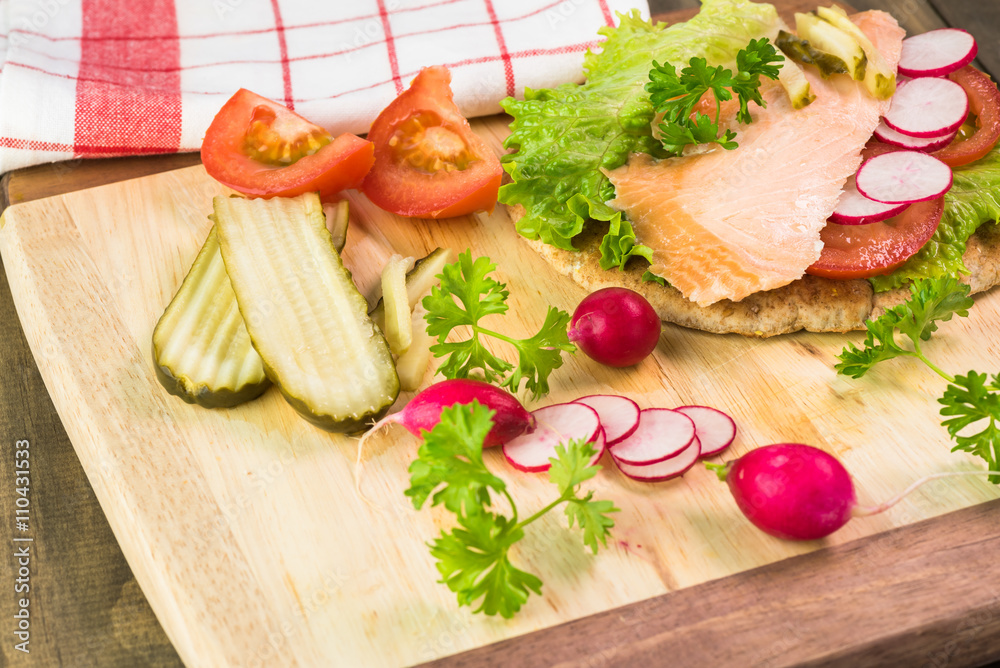 Fresh homemade pita sandwich with hot smoked salmon, letuce and vegetables. Fresh homemade pita sandwich with hot smoked salmon, letuce and vegetables.