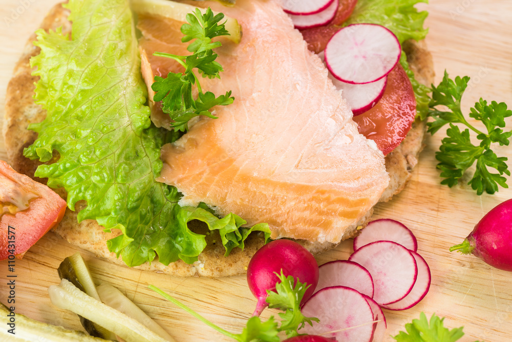 Fresh homemade pita sandwich with hot smoked salmon, letuce and vegetables. Fresh homemade pita sandwich with hot smoked salmon, letuce and vegetables.