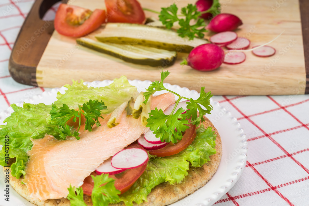 Fresh homemade pita sandwich with hot smoked salmon, letuce and vegetables.