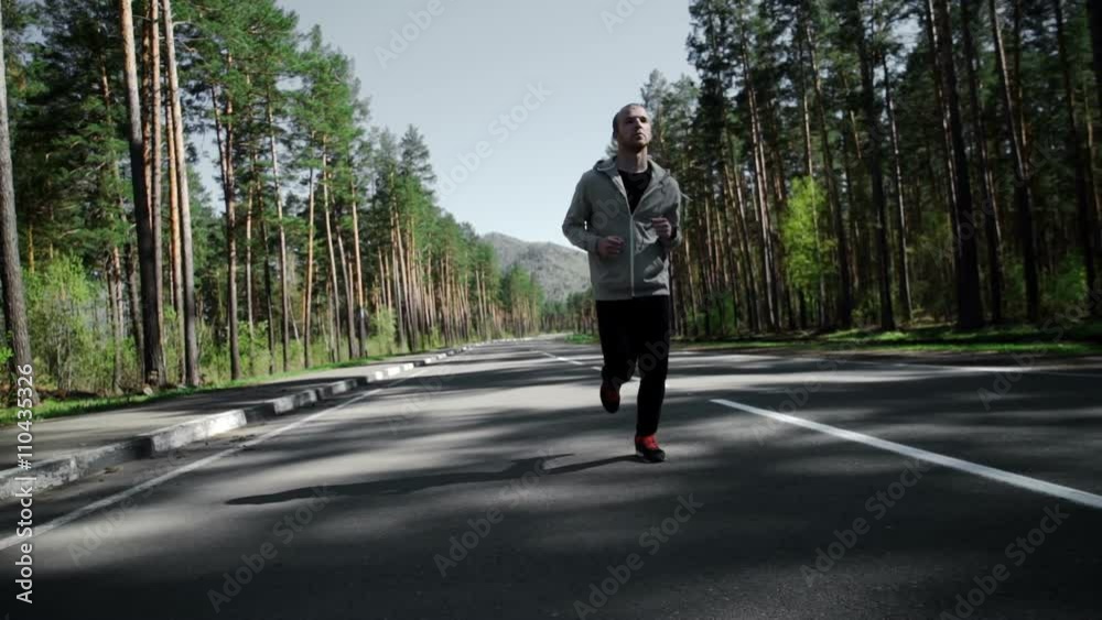Man running looking at his pulse outside in nature on road with smartwatch. Man running looking at his pulse outside in nature on road with smartwatch.