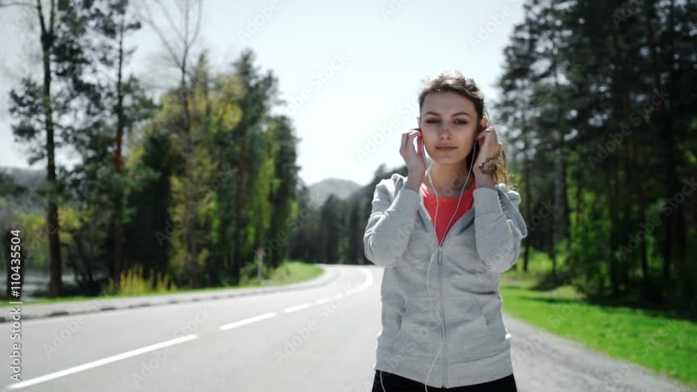 SLOW MOTION portrait of a young woman jogging and listening to the player SLOW MOTION portrait of a young woman jogging and listening to the player