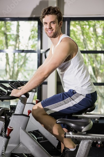 Man working out on exercise bike at spinning class