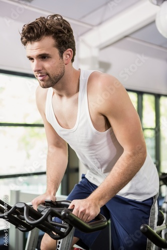 Man working out on exercise bike at spinning class © WavebreakMediaMicro
