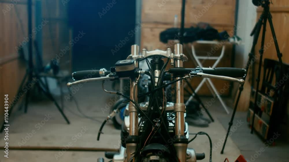 Young Caucasian male mechanic assembling a custom cafe racer motorcycle in a garage. 4K UHD 60 FPS slow motion. Blackmagic URSA Mini Young Caucasian male mechanic assembling a custom cafe racer motorcycle in a garage. 4K UHD 60 FPS slow motion. Blackmagic URSA Mini