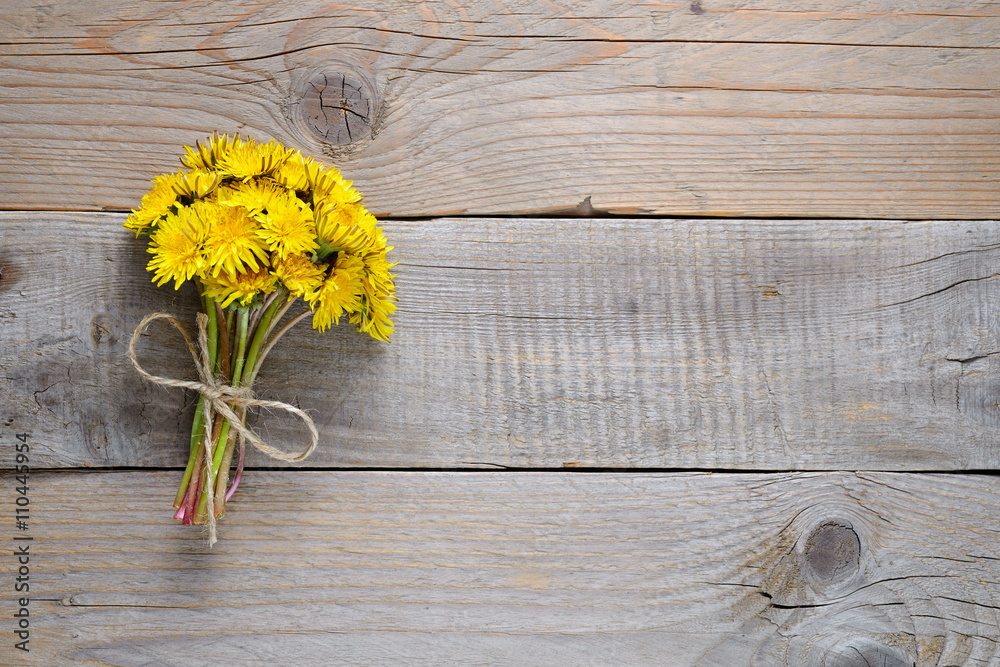 Obraz premium Bukiet dandelion kwitnie na drewnianym tle