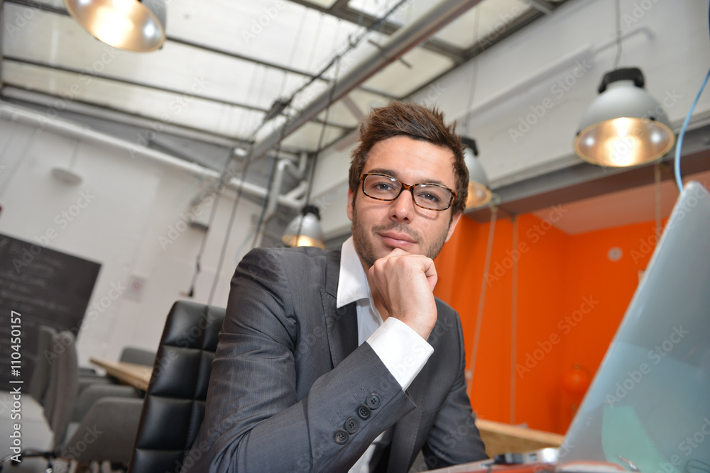 Portrait of smiling Businessman posing in coworking office Portrait of smiling Businessman posing in coworking office