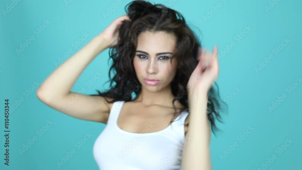 sexy brunette woman dancing and expressing on to the camera wearing white top
