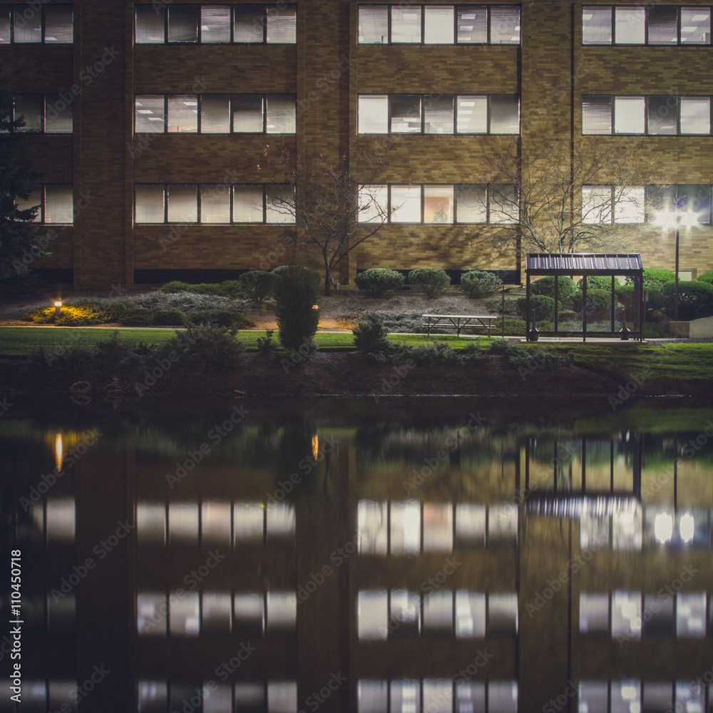 Obraz premium Long exposure of a office building and lake at night