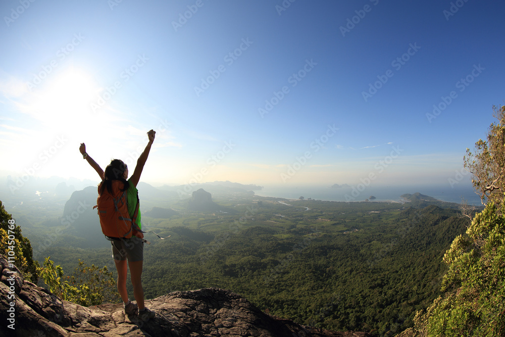 cheering woman hiker at sunrise mountain peak cheering woman hiker at sunrise mountain peak
