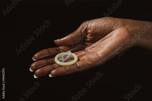 main femme noire tenant préservatif