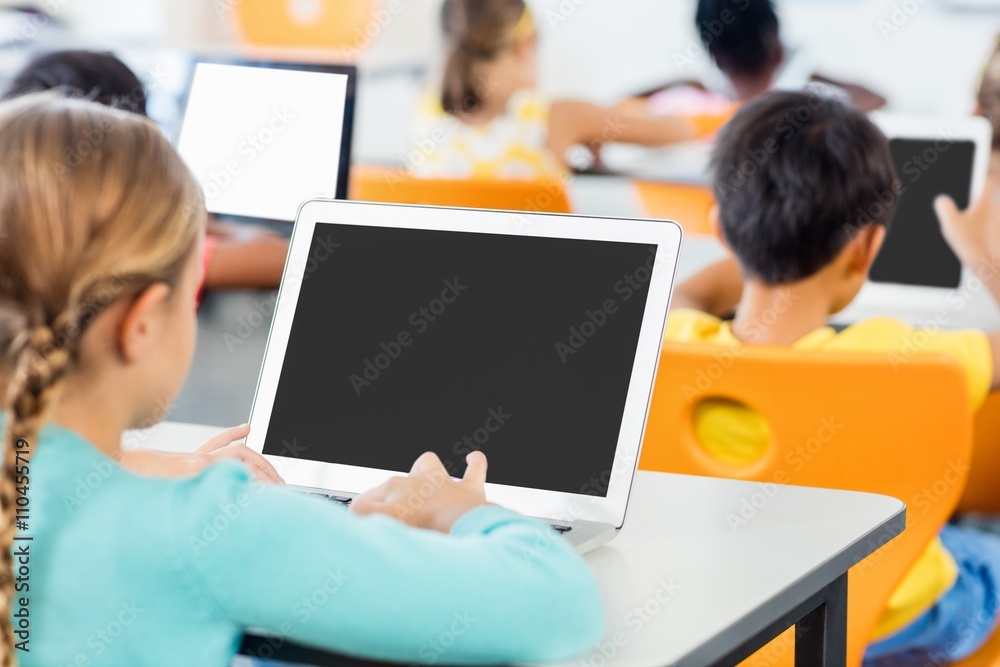 Rear view of pupils working in classroom with laptop Rear view of pupils working in classroom with laptop