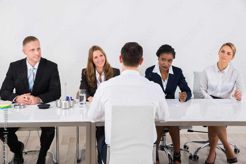 Businesspeople Interviewing Man