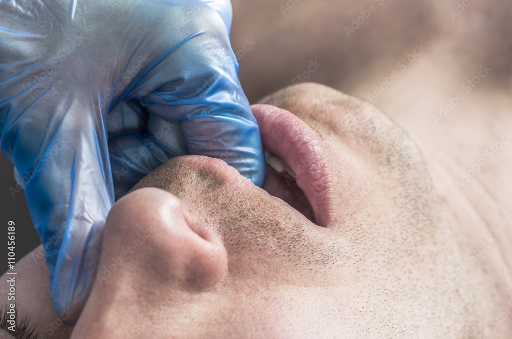 Naklejka premium Physiotherapist is doing intraoral technique of massage masseter