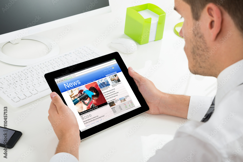 Man Reading News On His Digital Tablet Man Reading News On His Digital Tablet