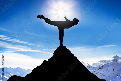 Man Practicing Balancing On A Peak Of A Mountain