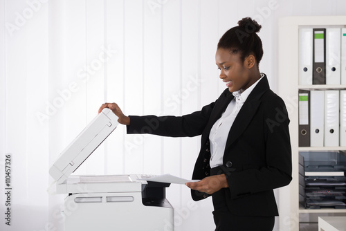 Smiling Businesswoman Using Photocopy Machine