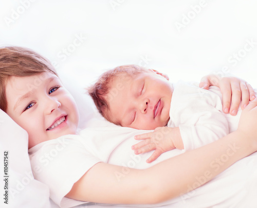portrait of cute happy siblings. young boy holding his infant br