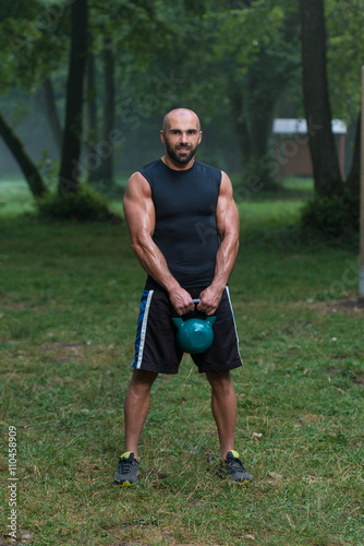 Attractive Male Athlete Performing A Kettle-Bell Swing