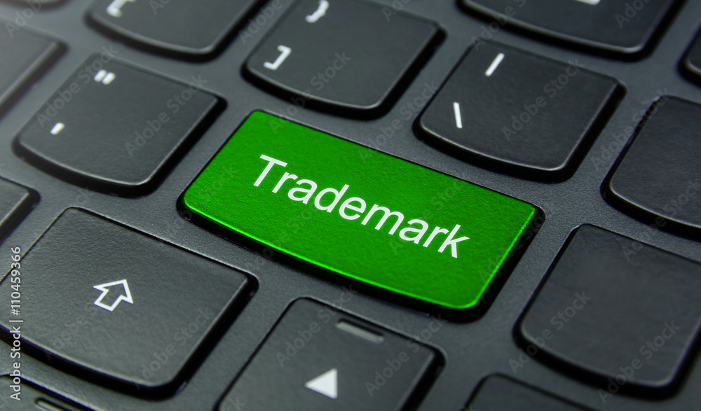 Business Concept: Close-up the Trademark button on the keyboard and have Lime, Green color button isolate black keyboard Business Concept: Close-up the Trademark button on the keyboard and have Lime, Green color button isolate black keyboard