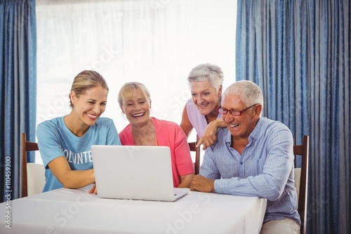 Seniors and woman using laptop