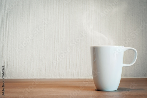 White cup of coffee on wooden table