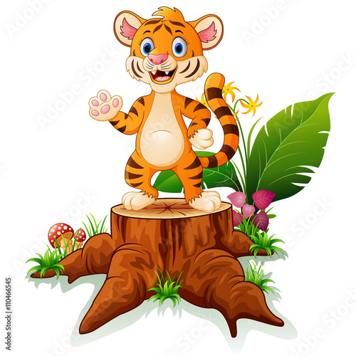 Fototapeta Naklejka Na Ścianę i Meble -  Cute baby tiger posing on tree stump 