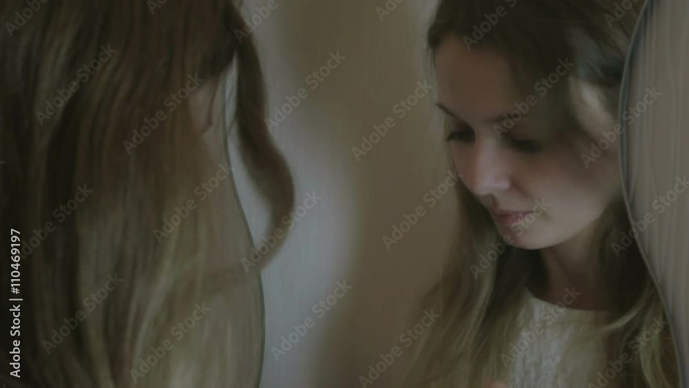 Beautiful girl paints lips before mirror. Beautiful girl paints lips before mirror.