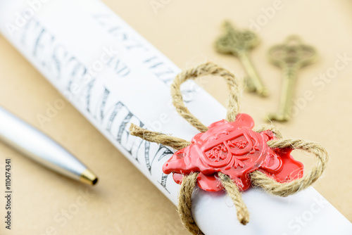 Rolled up scroll of Last will and testament that fastened with natural brown jute twine hemp rope, sealed with sealing wax and stamped with alphabet letter B. Decorated with two antique brass keys.