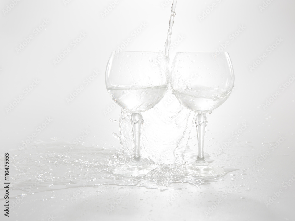 Water is pouring in two wine glasses Water is pouring in two wine glasses