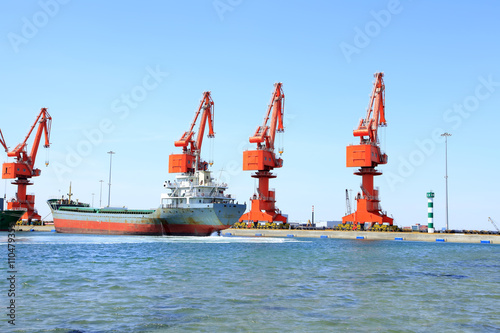 In freight terminal, gantry crane and cargo ships are in loading