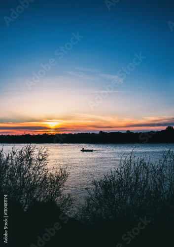 Fisherman's boat at beautiful sunset on the river