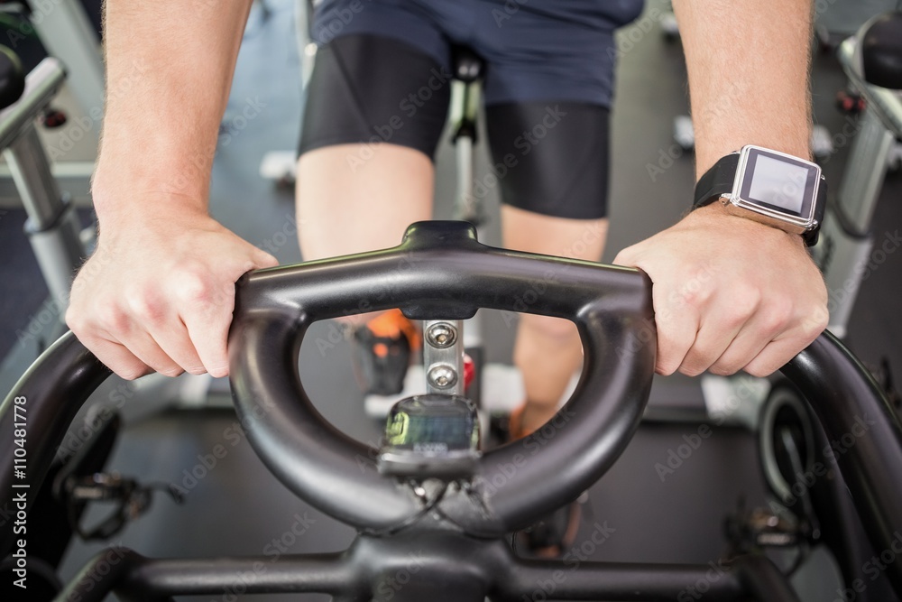 Man working out on exercise bike at spinning class Man working out on exercise bike at spinning class