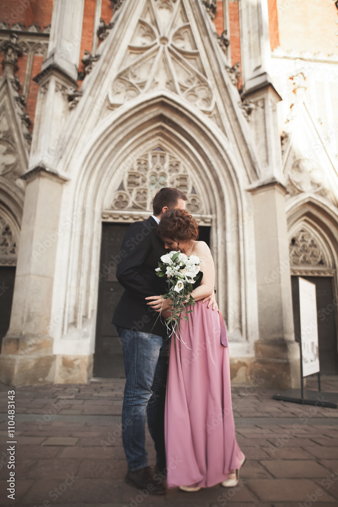 Gorgeous wedding couple, groom and bride with pink dress walking in the old city of Krakow