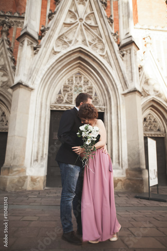 Gorgeous wedding couple, groom and bride with pink dress walking in the old city of Krakow © olegparylyak