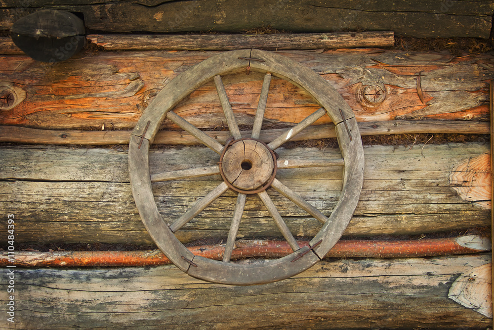 Old carriage wheel on old wood wall