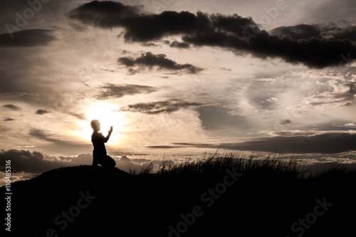boy praying at sunset time, sihouette concept