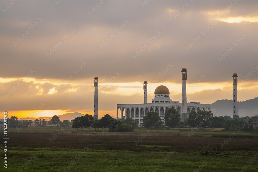 Beautiful mosque on green field with sunrise