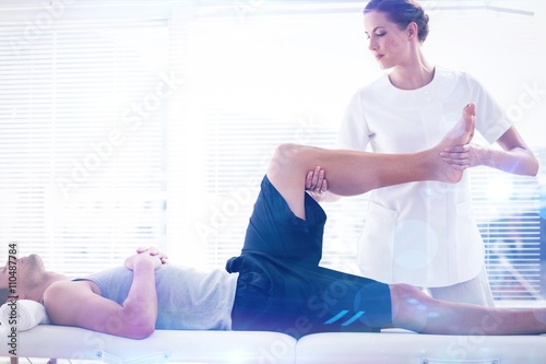 Composite image of physiotherapist massaging leg of man