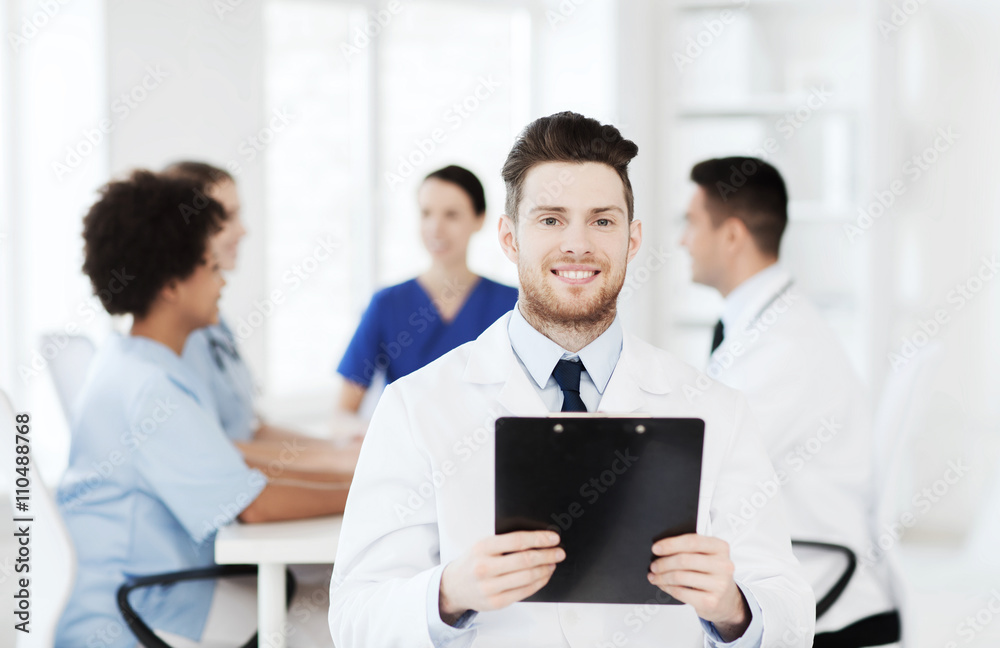 happy doctor with tablet pc over team at clinic happy doctor with tablet pc over team at clinic