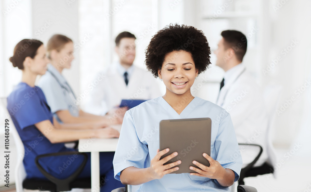 happy doctor with tablet pc over team at clinic happy doctor with tablet pc over team at clinic