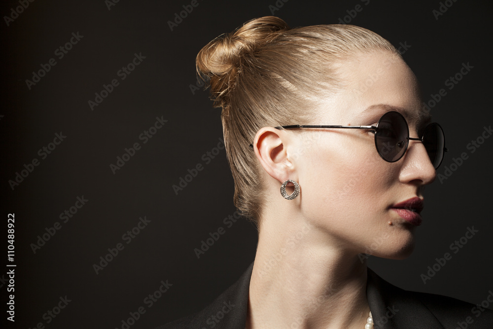 Portrait of Beautiful young woman in sunglasses on black backgro