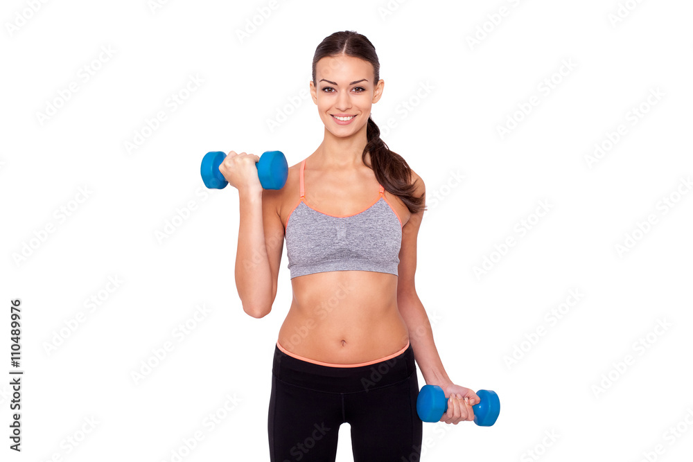 Keeping my body toned. Shot of a beautiful and sporty young woman lifting up weights against white isolated background. Keeping my body toned. Shot of a beautiful and sporty young woman lifting up weights against white isolated background.